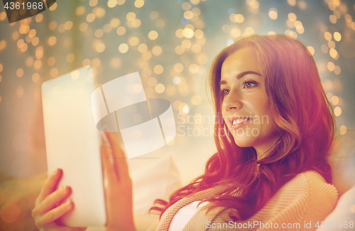 Image of happy young woman with tablet pc in bed at home