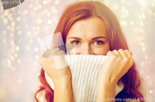 Image of young woman or teen girl pulling pullover collar