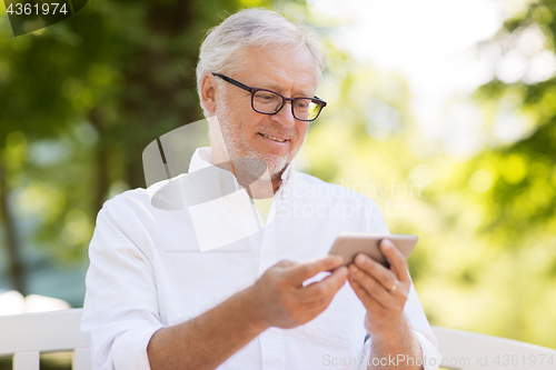 Image of senior man with smartphone at summer park