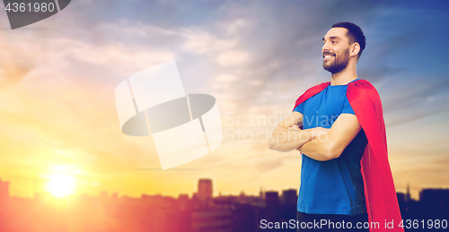 Image of man in red superhero cape over city background