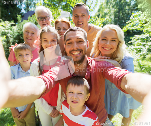Image of happy family taking selfie in summer garden