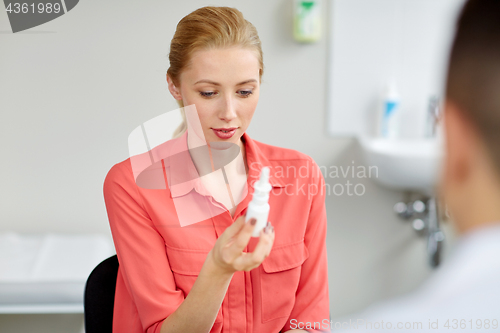 Image of woman with nasal spray and doctor at hospital