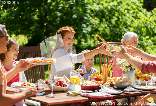 Image of happy family having dinner or summer garden party