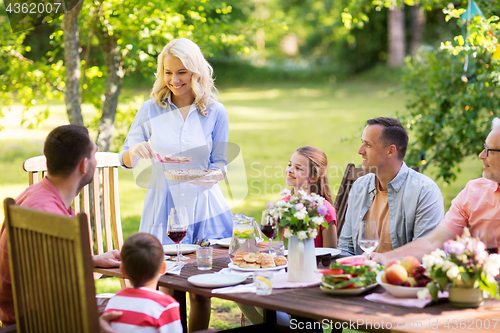 Image of happy family having dinner or summer garden party