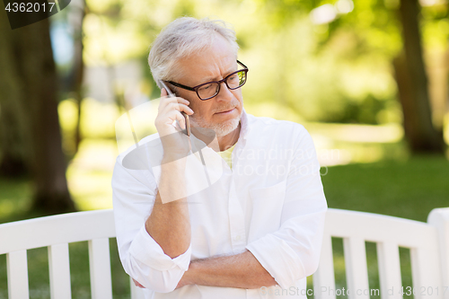 Image of senior man calling on smartphone at summer park