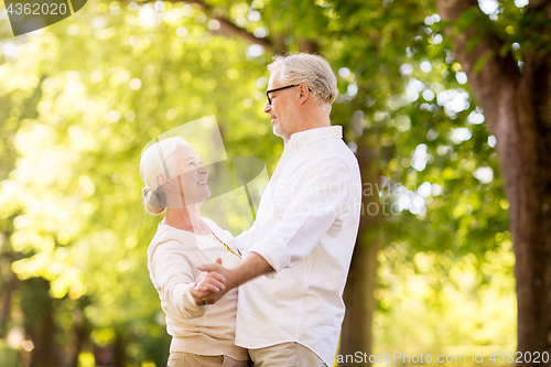 Image of happy senior couple dancing at summer park