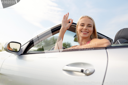 Image of happy young woman in convertible car