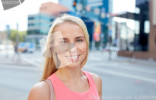 Image of happy smiling young woman on city street