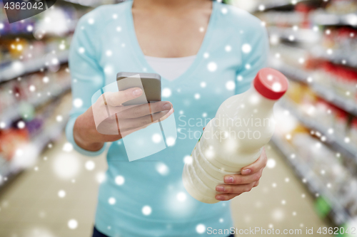 Image of customer with smartphone and milk at supermarket