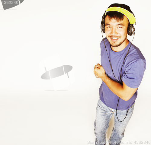 Image of young asian man in hat and headphones listening music on white b