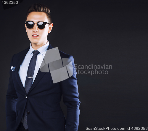 Image of young pretty business man standing on black background, modern h