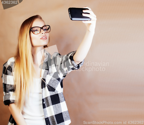 Image of young pretty blond woman with smartphone posing smiling, making 