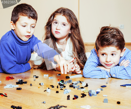 Image of funny cute children playing toys at home, boys and girl smiling, first education role close up, lifestyle people concept