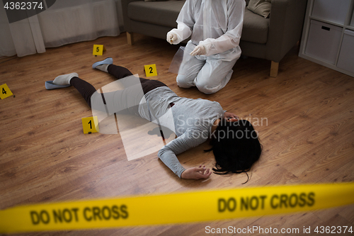 Image of criminalist collecting evidence at crime scene