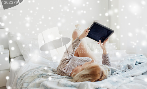 Image of happy young woman with tablet pc in bed at home