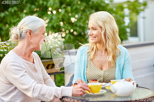 Image of daughter with senior mother drinking tea at cafe