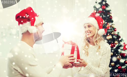 Image of happy couple at home with christmas gift box