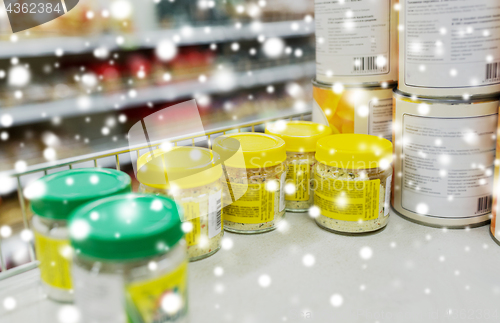 Image of jars with food or spices at grocery shelf