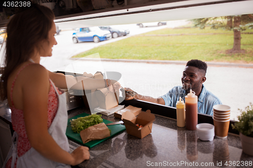 Image of african american man buying wok at food truck