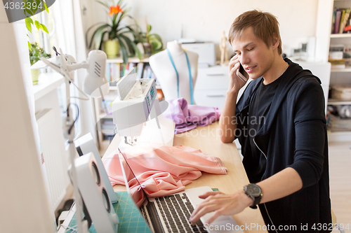 Image of fashion designer calling on smartphone at studio