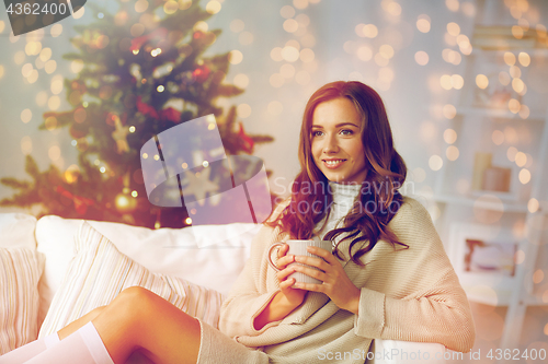 Image of happy woman with cup of tea at home for christmas