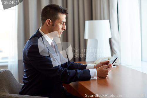 Image of businessman with tablet pc working at hotel room