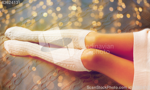 Image of close up of woman legs in winter knee socks in bed