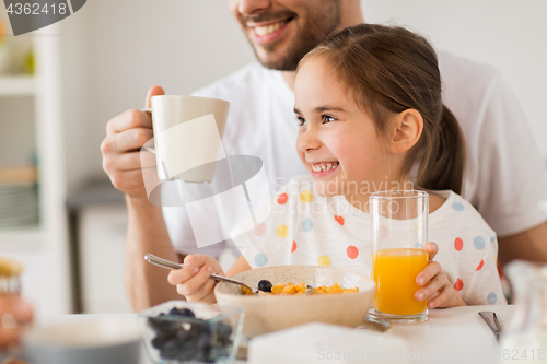 Image of happy family drinking juice for breakfast at home