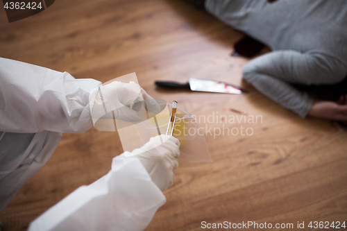 Image of criminalist collecting crime scene evidence