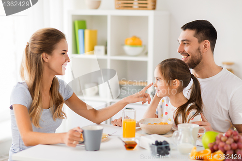 Image of happy family having breakfast at home