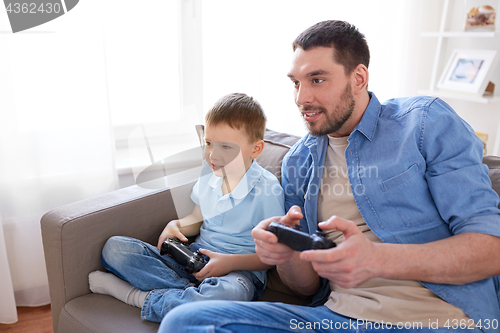 Image of father and son playing video game at home