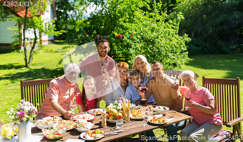 Image of happy family having dinner or summer garden party