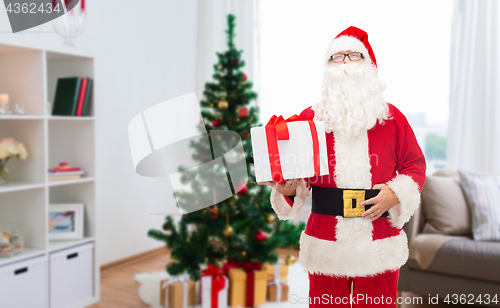 Image of santa claus with christmas gift at home