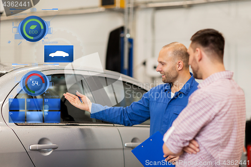 Image of auto mechanic with clipboard and man at car shop