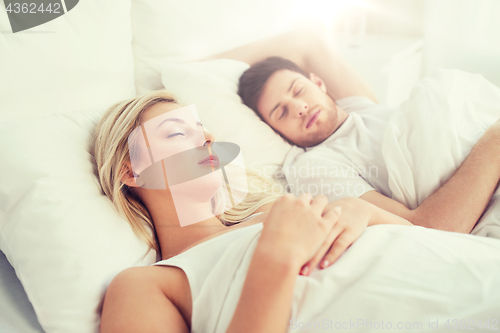 Image of happy couple sleeping in bed at home