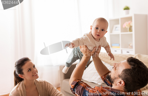 Image of happy mother and father playing with baby at home