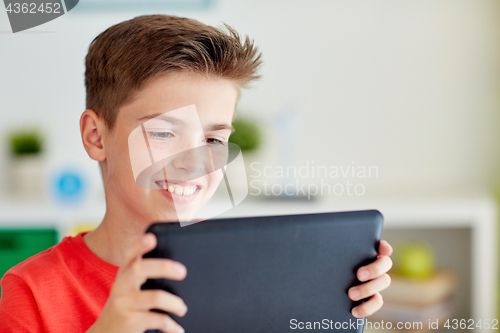 Image of close up of boy with tablet pc computer at home