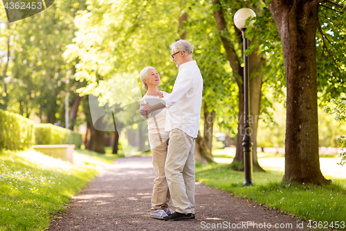 Image of happy senior couple dancing at summer park