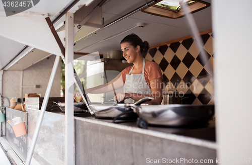 Image of happy chef or seller cooking at food truck