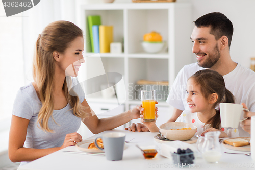 Image of happy family having breakfast at home