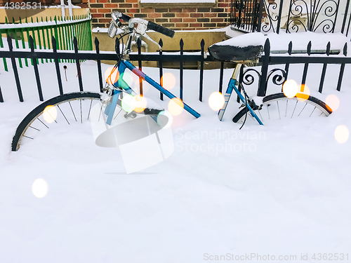 Image of Bicycle in snow near urban building, with bokeh light effect