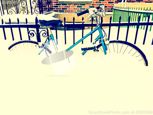 Image of Bicycle in snow near urban building, retro style photo