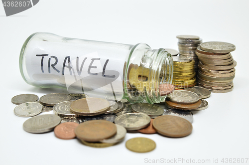 Image of Travel lable in a glass jar with coins spilling out