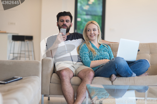 Image of young happy couple relaxes in the living room