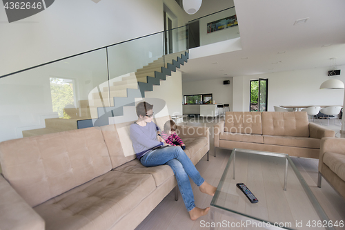 Image of mother and her cute little daughter are using a tablet