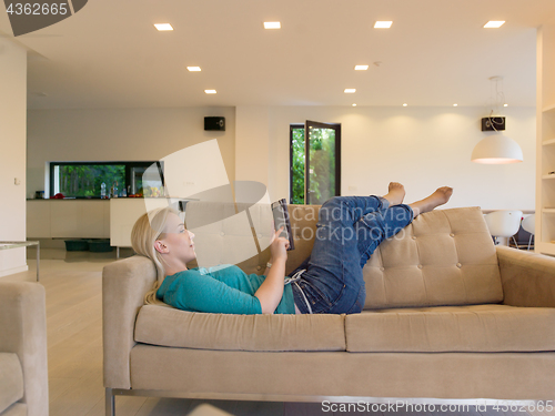 Image of woman on sofa using tablet computer