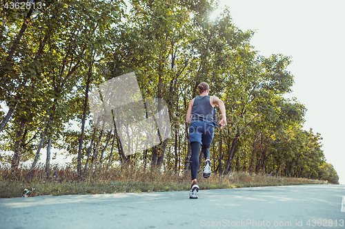 Image of Running sport. Man runner sprinting outdoor in scenic nature. Fit muscular male athlete training trail running for marathon run.