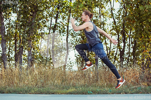 Image of Running sport. Man runner sprinting outdoor in scenic nature. Fit muscular male athlete training trail running for marathon run.