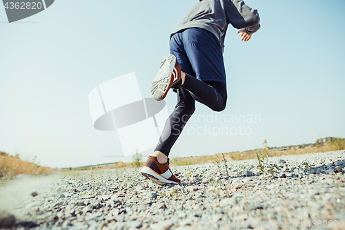 Image of Running sport. Man runner sprinting outdoor in scenic nature. Fit muscular male athlete training trail running for marathon run.