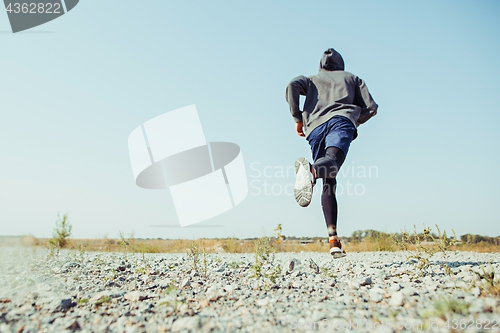 Image of Running sport. Man runner sprinting outdoor in scenic nature. Fit muscular male athlete training trail running for marathon run.
